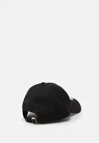 Casquette de baseball noire en matériau en maille, avec une visière courbée, une sangle réglable à l'arrière et un patch logo sur le côté.