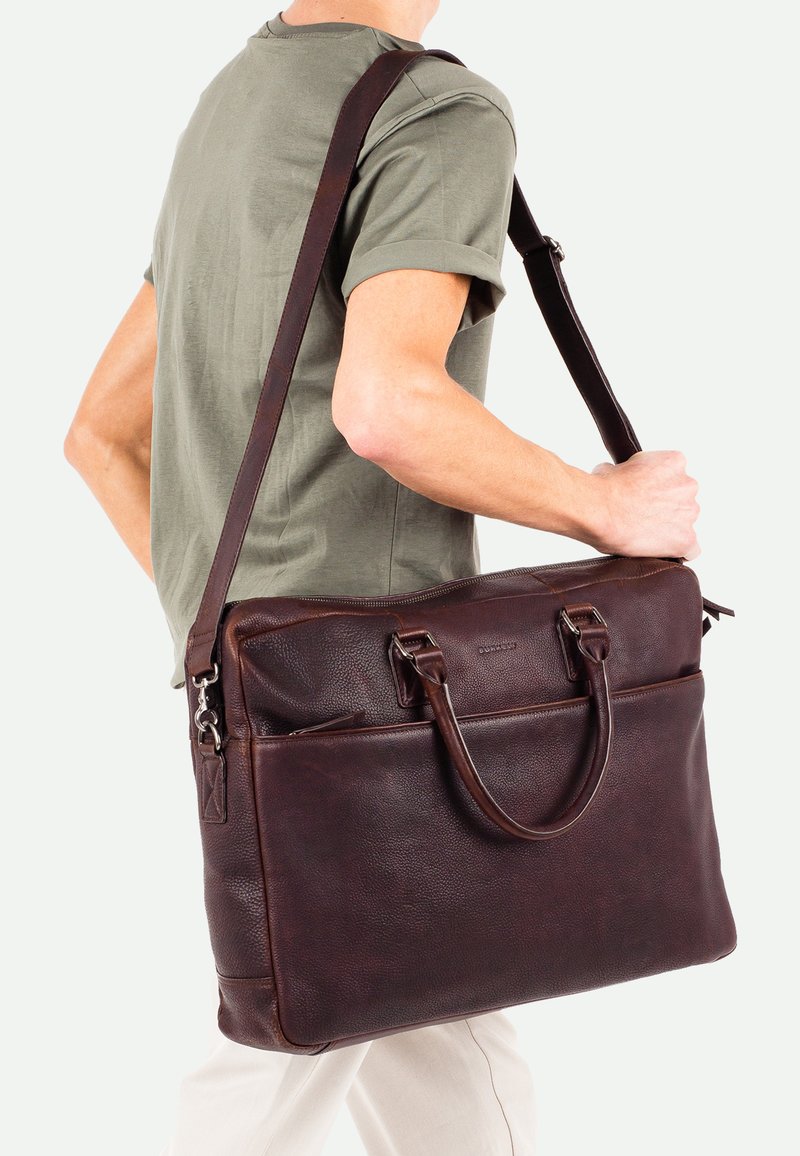 Braune Leder-Umhängetasche mit strukturiertem Finish, doppelten Griffen und verstellbarem Schulterriemen. Vordertasche mit Reißverschluss und sicheres Hauptfach.