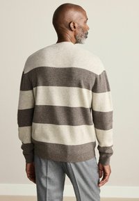 Knit sweater in beige and dark brown stripes, featuring a crew neck, long sleeves, and ribbed cuffs and hem.