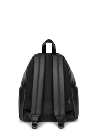 Mochila de tela negra con correas acolchadas para los hombros, bolsillo frontal con cremallera y un asa superior. Presenta una forma redondeada y un acabado texturizado.