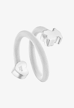 Anillo flexible de malla plateada con un extremo en forma de corazón grabado con "TOUS S925" y un extremo liso en forma de oso, diseño abierto.