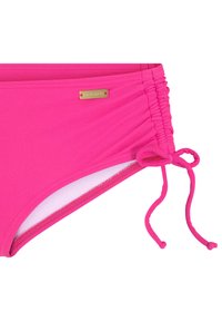 Różowy bikini dolny w intensywnym kolorze z marszczonymi bokami, zawiązywanymi akcentami i małą prostokątną złotą metką marki. Gładki, elastyczny materiał.