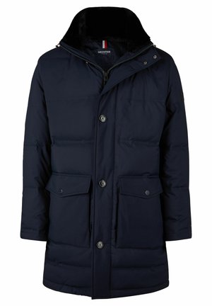 Marine blauwe pufferjas met een ritskraag, twee vo pockets, knoopsluitingen en een zachte bontvoering. Bevat een logo-detail op de mouw.