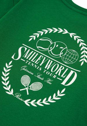 Groene katoenen t-shirt met een witte tennis-thema graphic, "SMILEY WORLD," en lauriert ontwerp, met accenten van tennisballen en rackets.