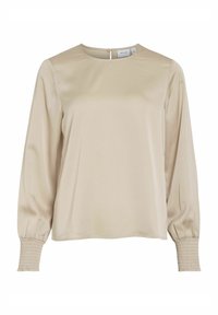 Beige blus med lång ärm och rund halsringning, knäppning bak och smocksmanchetter. Slätt tyg med en subtil lyster.