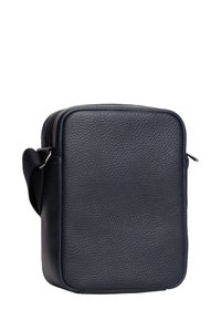 Laivastonsininen, teksturoitu nahkalaukku suorakaiteen muotoisena, vetoketjulla suljettava ja säädettävällä olkahihnalla. Minimalistinen muotoilu, jossa ei ole näkyvää metalliosaa.