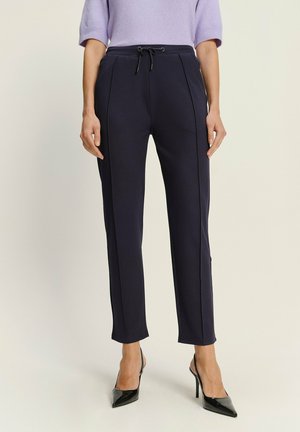 Navy Jogginghosen aus Baumwollmischung, mit einem Kordelzugbund, seitlichen Taschen und schmal zulaufenden Beinen mit dezenten Nähdetails.