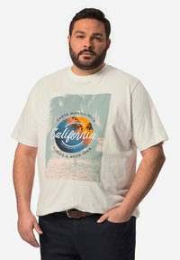 Camiseta de algodón color crema con un estampado gráfico de palmeras, un sol naranja y texto sobre California, en un diseño de corte relajado.