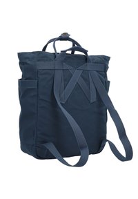 Zaino in nylon blu navy con doppie spalline, manici superiori e tasche laterali. Presenta una forma strutturata e una texture durevole.