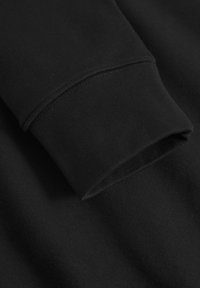 Black long-sleeve sweatshirt featuring a rounded cuff, soft fabric, and a smooth texture. Minimalist design with no visible logos or patterns.