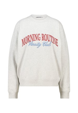 Lichtgrijze sweatshirt met een ronde hals en lange mouwen. Voorzien van rode en blauwe tekst met "MORNING ROUTINE Varsity Club." Zachte stof.