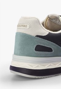 Tenisky s horní částí z šedé tkaniny, tyrkysovým semišovým panelem, bílými akcenty a texturovanou podrážkou. Mají logo na patě a výřezové designové prvky.