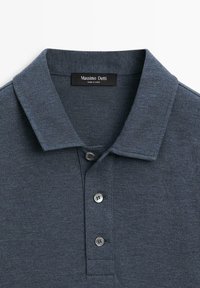Marineblå strikket poloshirt med krave, to-knaps åbning og en tekstureret stoffinish. Mærket lyder "Massimo Dutti."