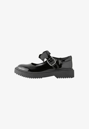 Zwarte lakleren Mary Jane-schoen met dikke rubberen zool, zilveren gesp en decoratieve stoffen strik op het bandje.
