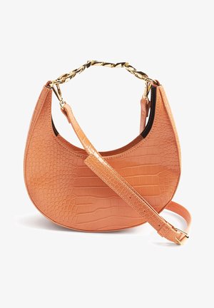 Borsa a mezzaluna tan con texture in coccodrillo, manico a catena dorata e tracolla regolabile con fibbia su sfondo bianco.