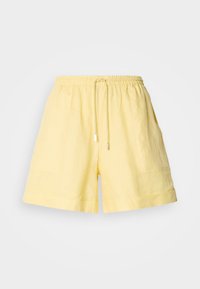 Yellow linen shorts with an elastic waistband, drawstring closure, side pockets, and rolled cuffs. Lightweight and breathable fabric.