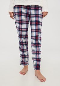 Pantaloni del pigiama a quadri in blu navy, rosso e bianco. Realizzati in tessuto morbido, presentano una vestibilità comoda e un design a gamba dritta.