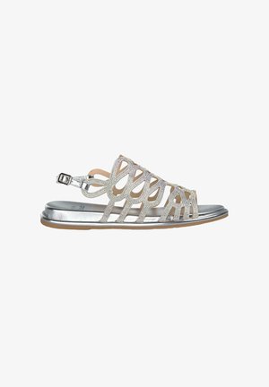 Sandalia plateada con diseño recortado, tiras texturizadas y pulsera con hebilla en el tobillo. Acabado metálico liso en la suela, perfil plano.