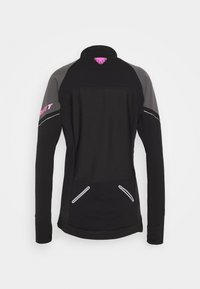 Veste noire à manches longues avec des empiècements d'épaule gris, logo rose sur le col, et accents réfléchissants. Comprend deux poches avant.