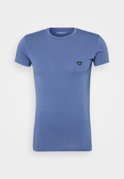Short-sleeve blue t-shirt made of cotton, round neckline, slim fit, featuring a small black and blue logo on the chest.