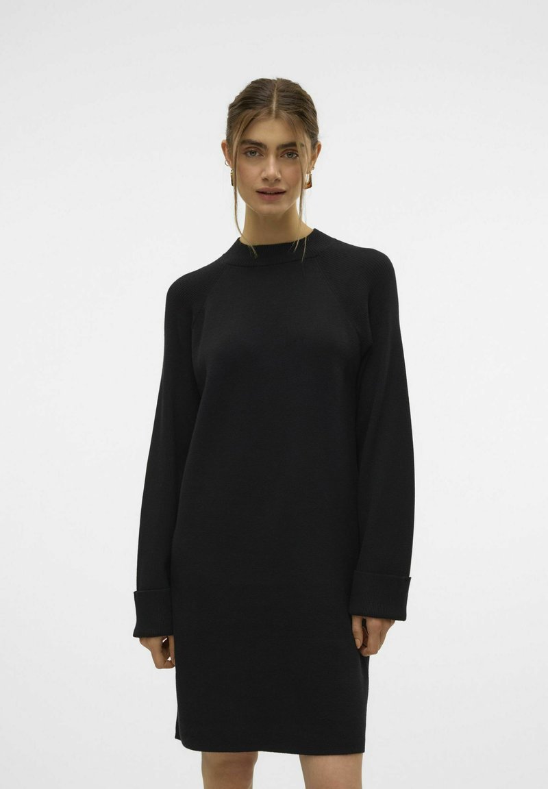 Schwarz Kleid mit langen Ärmeln, Rundhalsausschnitt und gerippter Textur. Verfügt über umgekrempelte Ärmel und eine lockere Passform. Einfaches und vielseitiges Design.