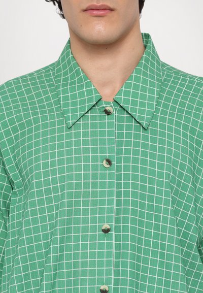 Green checkered shirt made of cotton, featuring a pointed collar, button closure, and contrasting white grid pattern.