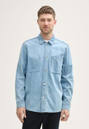 Hellblaues Denimhemd mit Kragen, Knopfleiste vorne und Brusttasche, mit einem lässigen Schnitt und leicht strukturiertem Stoff.