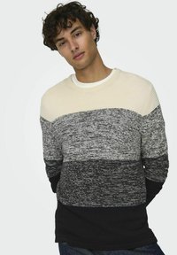 Maglione lavorato a maglia con righe orizzontali in crema, grigio e nero. Texture a coste su spalle e polsini. Collo a giro.