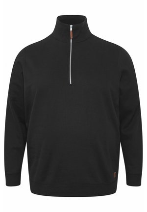 Black pullover sweater with a high collar, half-zip front, long sleeves, and a textured fabric. Features a small brown logo tag at the hem.