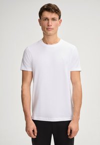 White short-sleeve t-shirt made of cotton, featuring a crew neckline and a small embroidered logo on the chest. Smooth fabric texture.