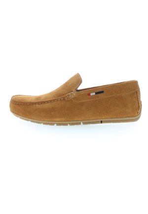 Brun ruskinds slip-on sko med lav profil og let gummisål; har dekorativ syning og en lille brandaccent i rød, hvid og blå.