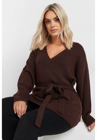 Brun innesvept tröja i mjukt stickat tyg med ett knytbälte i midjan, med långa ärmar och en djup V-halsdesign.