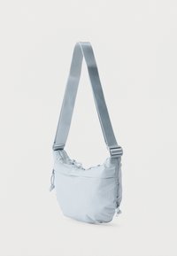 Φωτεινό γαλάζιο τσαντάκι ώμου με ρυθμιζόμενο ιμάντα, φερμουάρ στην κορυφή και λεπτομέρειες με κορδόνι σε απλό λευκό φόντο.