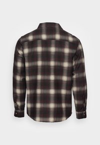 Koszula flanelowa w kratę o kolorystyce bordowej, czarnej i kremowej, z długimi rękawami i mankietami zapinanymi na guziki, umożliwiającymi regulację.