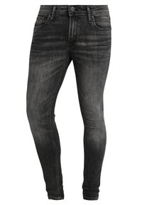 Jeans de mezclilla negra de corte ajustado, con detalles de desvanecimiento, bolsillos frontales, cierre de botón y costuras cosidas.
