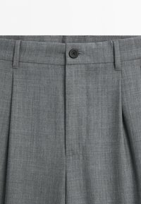 Gray dress pants with a black button closure, belt loops, and a front crease detail.
