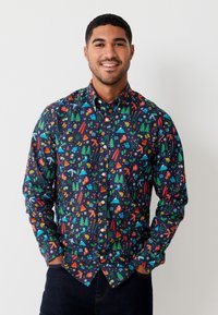 Camicia con bottoni blu scuro con motivi festivi colorati che includono alberi, fiocchi di neve e accessori invernali; maniche lunghe, vestibilità regolare.