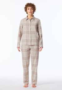 Beige rutigt pyjamas-set bestående av en knäpparöverdel med långa ärmar och matchande raka byxor, tillverkade av ett mjukt, lätt tyg.