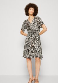 Robe portefeuille à imprimé léopard avec des manches courtes et un décolleté en V. Tissu fluide, taille cintrée, longueur au genou et surface douce et texturée.