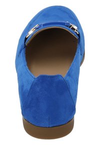 Zapato de ante azul con punta redondeada, textura suave y una correa brillante en la parte superior. Suela de goma marrón con un dibujo mínimo.