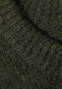 Olivgrüner Strickpullover aus einem Stoff mit strukturiertem Muster, das sichtbare Fasern aufweist und ein dickes, gemütliches Aussehen hat.