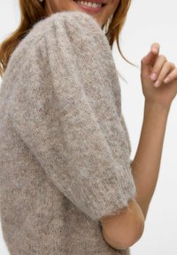 Maglione beige lavorato a maglia con maniche corte a sbuffo, caratterizzato da una consistenza morbida e pelosa e un motivo sottile su tutto il tessuto.