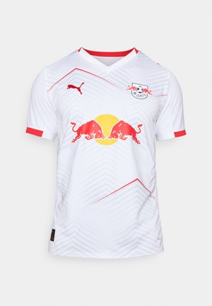 Weißes Fußballtrikot mit roten Akzenten, V-Ausschnitt, mit einem geometrischen Muster, Red Bull-Logo und dem Puma-Logo auf der Schulter.