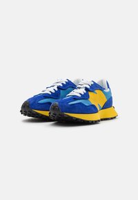 Sneakers in blue, yellow, and turquoise suede, featuring white laces and a textured black rubber sole with traction patterns.