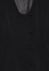 Vestito nero con scollo a V, caratterizzato da cinque bottoni rotondi sul davanti e un tessuto liscio e testurizzato.