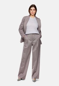 Gray striped suit with a loose fit, featuring a light blue lace-patterned sweater beneath. Soft fabric with wide-leg trousers and flats.