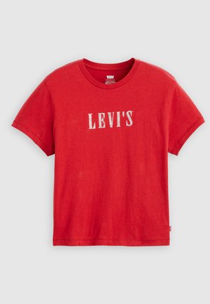 Crvena majica kratkih rukava od pamuka, s bijelim "LEVI'S" logotipom preko prsa. Klasičan dizajn s okruglim izrezom, meka tekstura.