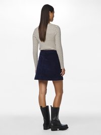 Ναυτικό μίνι φούστα από κορντούρα συνδυασμένη με μακριά μπλούζα με ρίγες και μαύρες μπότες μέχρι το γόνατο; διαθέτει εφαρμοστό waist και άλφα σχήμα.