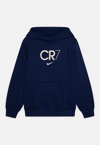 Námořnická modrá mikina s kapucí vyrobená z měkké tkaniny, obsahující přední klokaní kapsu, krémový grafický motiv CR7 a malé logo Nike.