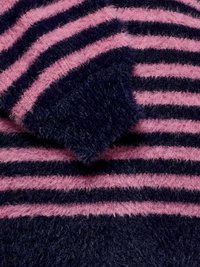 Bolyhos pulóver tengerészkék és rózsaszín vízszintes csíkokkal. Puha textúrájú, bő szabású és kerek nyakú. A csíkok szélessége változó.